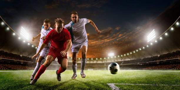 istock Soccer players in action on sunset stadium background panorama 502180310