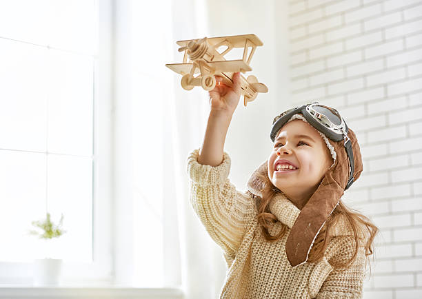 девочка играет с игрушка самолет - aspirations pilot child airplane стоковые фото и изображения