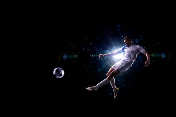 istock Soccer player in action over black background 502180394