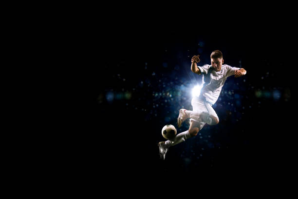istock Soccer player in action over black background 502180462
