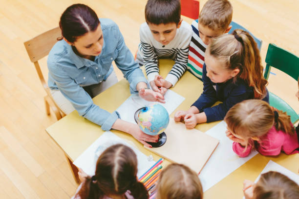 istock Preschool teacher teaching children in classroom. 502181424