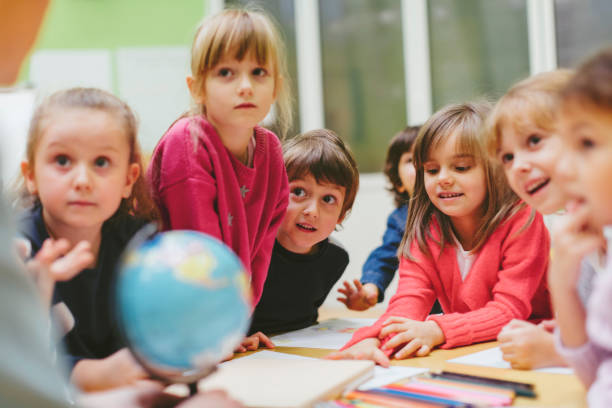 Preschool teacher and children learning in classroom.