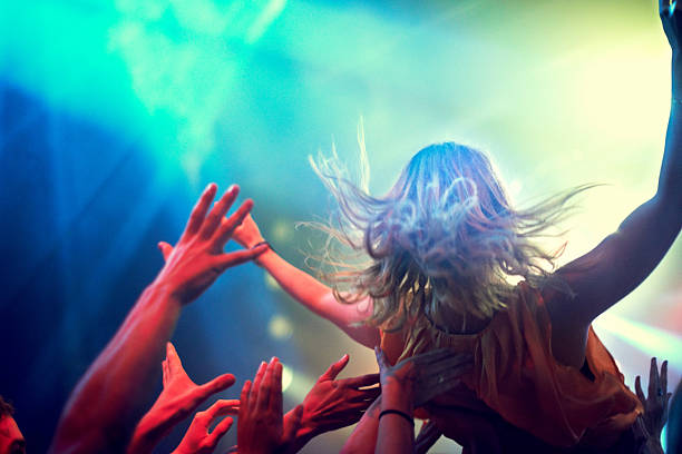 Crowd surfing! A young girl crowd surfing as a band plays one of her favourite songshttp://195.154.178.81/DATA/i_collage/pi/shoots/782538.jpg mosh pit stock pictures, royalty-free photos & images