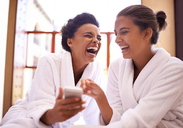 #Girls day at the spa! Shot of two friends in bathrobes laughing at a texthttp://195.154.178.81/DATA/i_collage/pi/shoots/783620.jpg bathrobe photos stock pictures, royalty-free photos & images