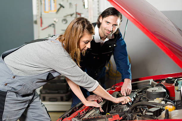 istock Auto mechanic guiding a female trainee in garage 502192438