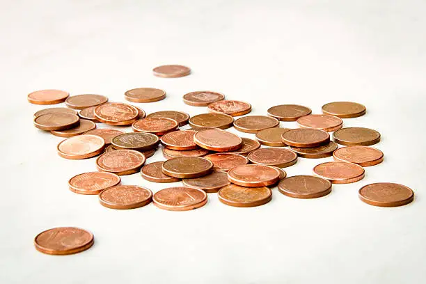 Some shiny one euro cent coins on a pile isolated on a white background.