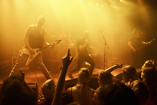 Rearview of fans dancing with their hands in the air at a rock concert. This concert was created for the sole purpose of this photo shoot, featuring 300 models and 3 live bands. All people in this shoot are model released.