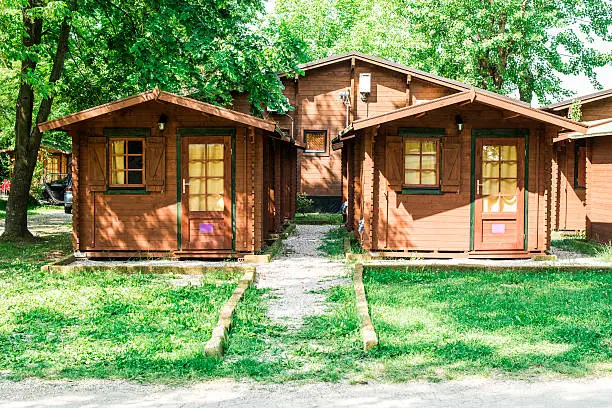 Wooden bungalows on campsite camping. Green trees
