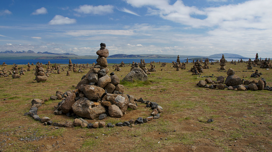 Field of stone cairns along the Golden Circle in Iceland's Highland Region.  The backdrop is Thingvellir National Park and Lake Thingvallavatn.