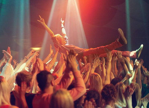 A young man crowd surfing to his favorite band. This concert was created for the sole purpose of this photo shoot, featuring 300 models and 3 live bands. All people in this shoot are model released.