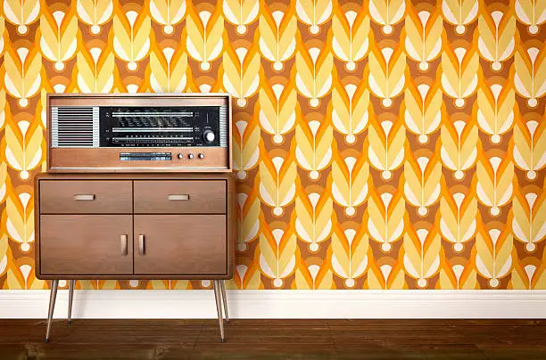 Photo of Vintage old radio on sixties, seventies wallpaper and furniture