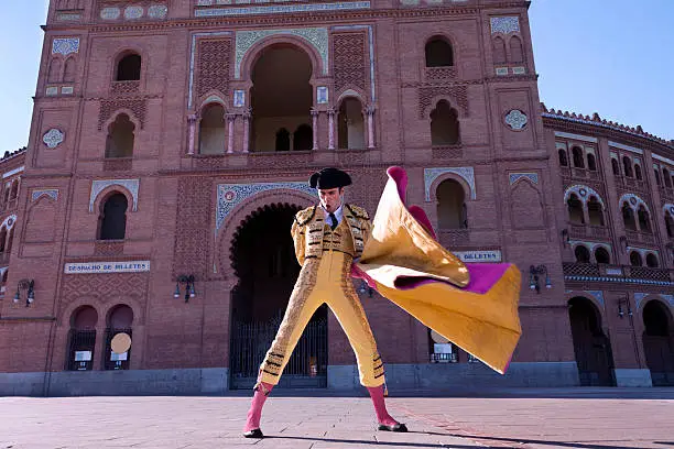 Bullfighter in front of the main gate of bullring Las ventas, Madrid, Spain. Because the bullring facade shown in the picture (Madrid, Las Ventas Bullring) is owned by the municipality of Madrid, images taken of the exterior building are of public domain, therefore a property model release is not necessary. Also, the Las Ventas Bullring, is not linked to any particular bullfighter, nor private companies.