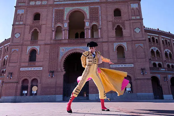 Bullfighter in front of the main gate of bullring Las ventas, Madrid, Spain. Because the bullring facade shown in the picture (Madrid, Las Ventas Bullring) is owned by the municipality of Madrid, images taken of the exterior building are of public domain, therefore a property model release is not necessary. Also, the Las Ventas Bullring, is not linked to any particular bullfighter, nor private companies.