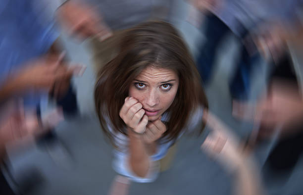 Surrounded by self-doubt Conceptual shot of an anxious young woman in the middle of a circle of accusing coworkershttp://195.154.178.81/DATA/i_collage/pi/shoots/783578.jpg terrified stock pictures, royalty-free photos & images