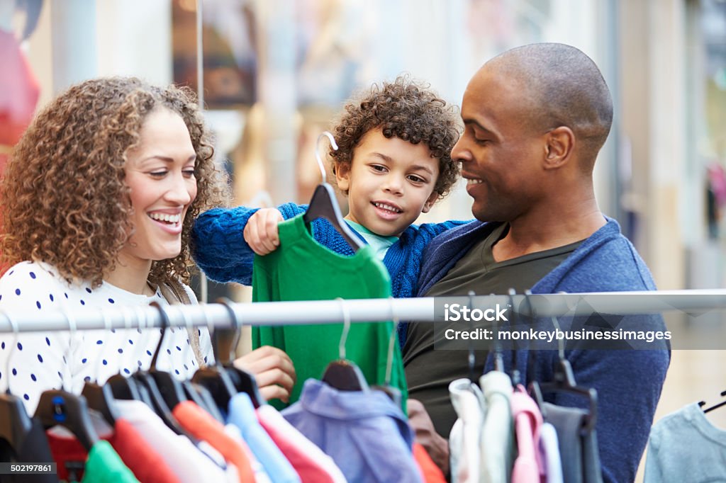 Family Looking At Clothes On Rail In Shopping Mall Family Looking At Clothes On Rail In Shopping Mall Having Fun Shopping Stock Photo