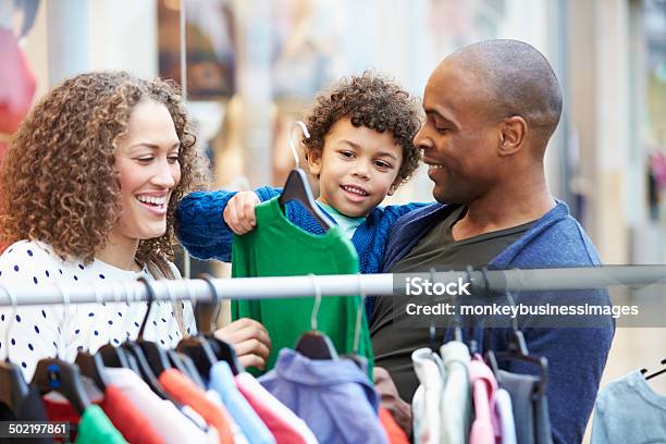 Family Looking At Clothes On Rail In Shopping Mall Stock Photo - Download Image Now - Shopping, Retail, Child