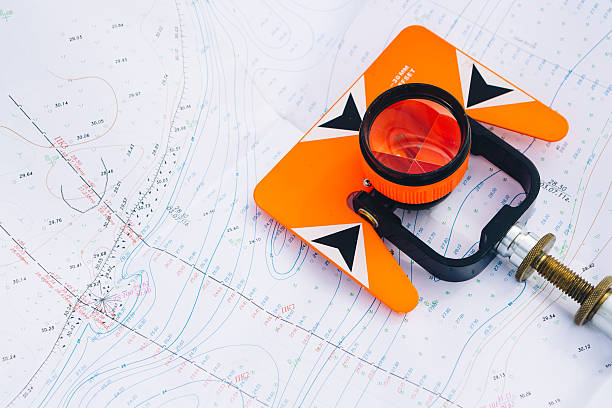 istock orange theodolite prism lies on a background geodetic maps 502209632