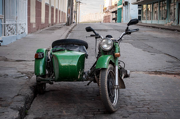 Old motorcycle with sidecar Green vintage motorcycle with sidecar parked on a street in Cienfuegos. baracoa stock pictures, royalty-free photos & images