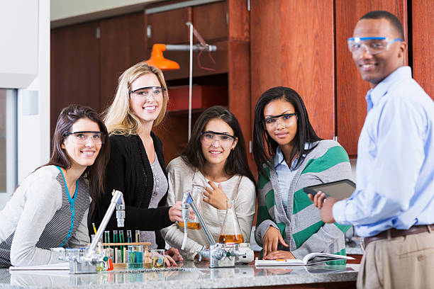 istock Female students with teacher in science class 502219177