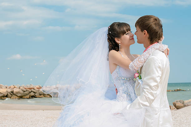 Young and beautiful bride and groom on the beach stock photo