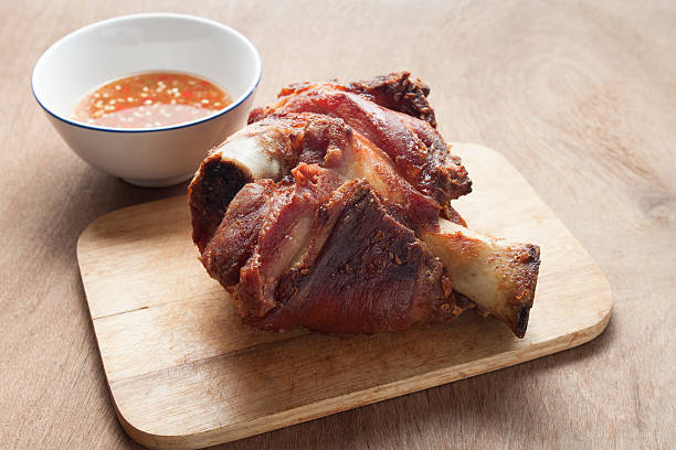 istock German BBQ pork knuckle served with sauce on wood background 502224834