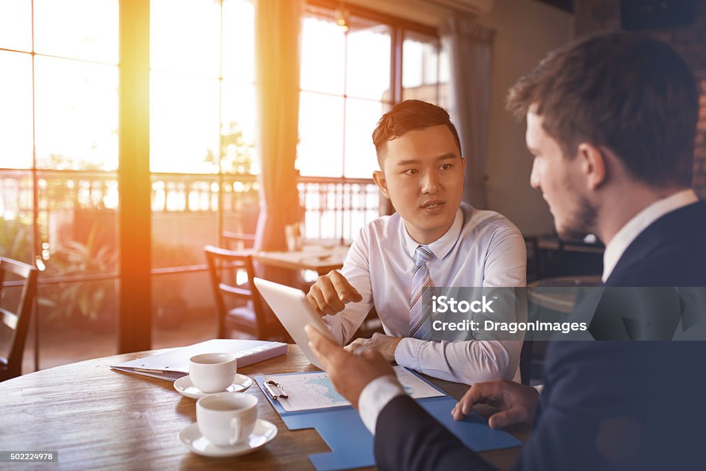 Discussing project Two businessmen sitting in cafe and discussing business project Entrepreneur Stock Photo