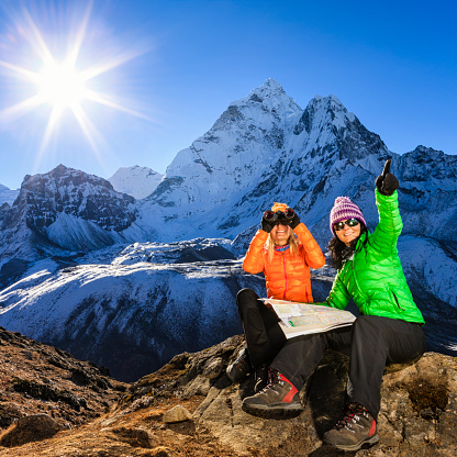 Young women studying map in Himalayas during the sunrise, Mount Ama Dablam on background. One woman is wearing green jacket, second wearing orange jacket. Mount Everest National Park. This is the highest national park in the world, with the entire park located above 3,000 m ( 9,700 ft). This park includes three peaks higher than 8,000 m, including Mt Everest. Therefore, most of the park area is very rugged and steep, with its terrain cut by deep rivers and glaciers. Unlike other parks in the plain areas, this park can be divided into four climate zones because of the rising altitude. 