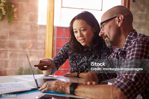 Two Designers With Laptop Meeting In Modern Office Stock Photo - Download Image Now - Meeting, Casual Clothing, Office