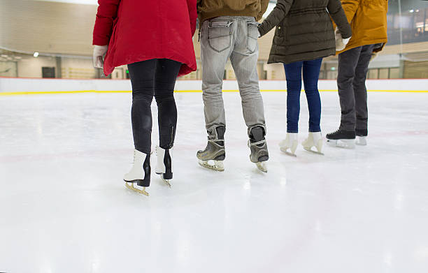 close up of happy friends skating on ice rink people, friendship, sport and leisure concept - close up of happy friends skating on ice rink ice rink stock pictures, royalty-free photos & images