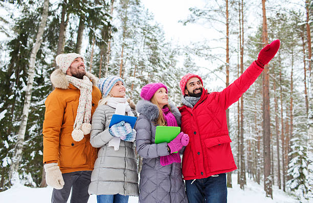 istock smiling friends with tablet pc in winter forest 502258642