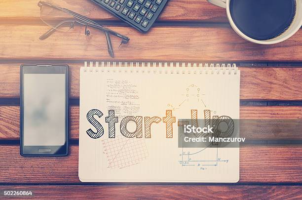 Notebook With Text Inside Start Up On Table Stock Photo - Download Image Now - 2015, Business, Business Finance and Industry