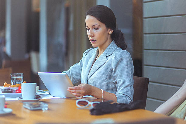 istock Young businesswoman using her digital tablet at restaurant 502261100