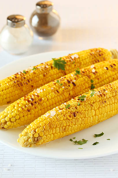 istock Fresh tasty grilled corn on white plate 502261172