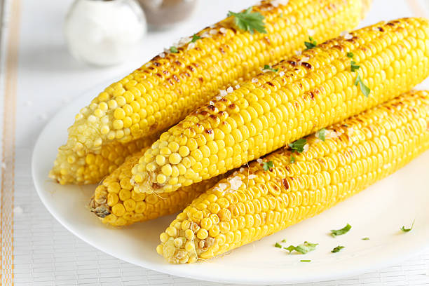 istock Fresh tasty grilled corn on white plate 502261276