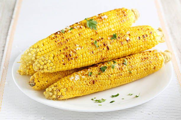 Fresh tasty grilled corn on white plate stock photo