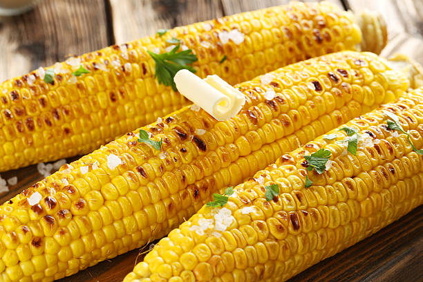 istock Fresh tasty grilled corn with butter on brown table 502262102