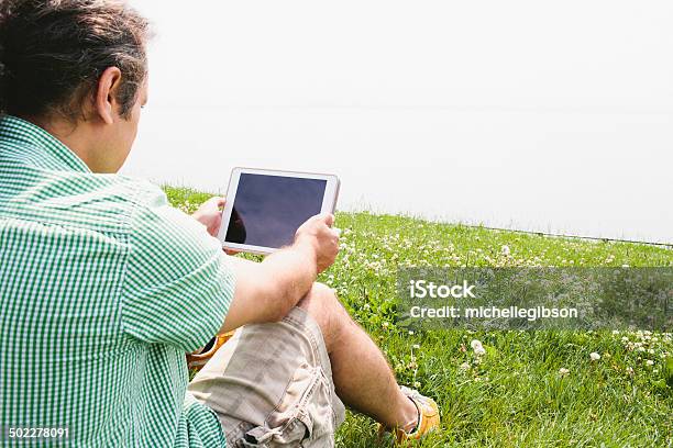 Uomo Utilizzando Un Computer Tavoletta Digitale Allaperto In Natura - Fotografie stock e altre immagini di Abbigliamento casual