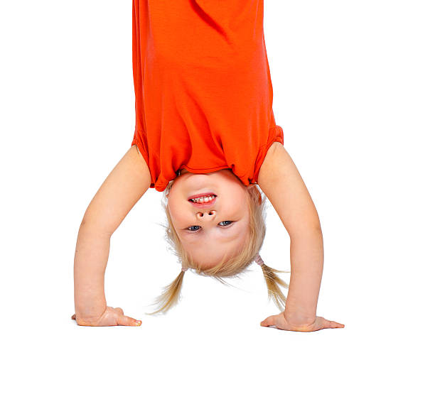 istock Cute little girl hanging upside down 502281550