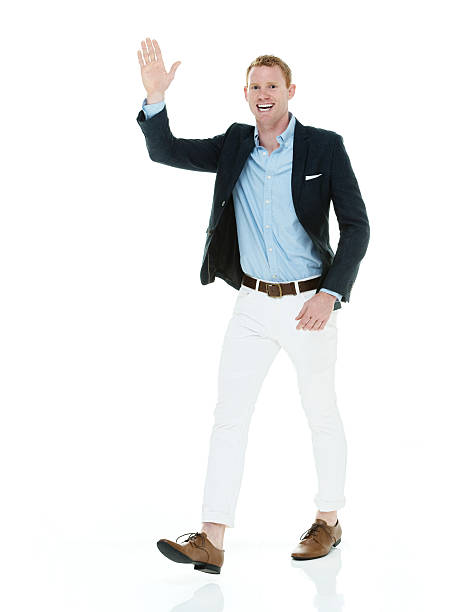 istock Smiling businessman waving hand and walking 502282250