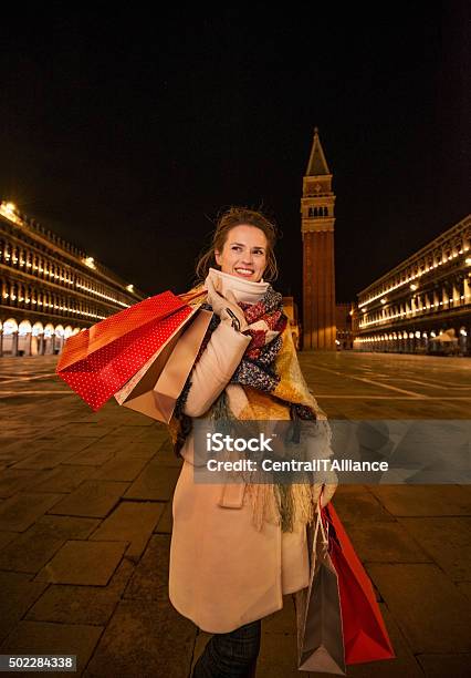 Playful Woman Holding Shopping Bags On Piazza San Marco Venice Stock Photo - Download Image Now