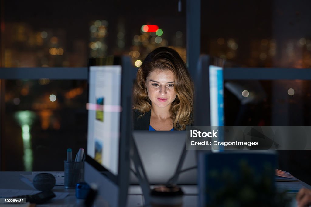 Computing late at night Business lady looking at glowing screen of her laptop Laptop Stock Photo