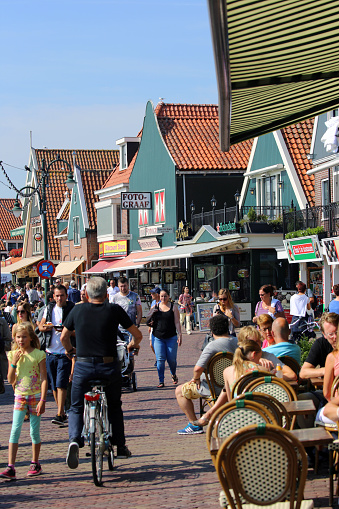 Volendam, Netherlands - August 20, 2015: Tourists stroll along the main street of Haven in the traditional Dutch town of Volendam. The town is located on the Ijsselmeer and has a seaside resort atmosphere.