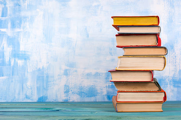 istock Stack of colorful hardback books, open book on blue background 502289574