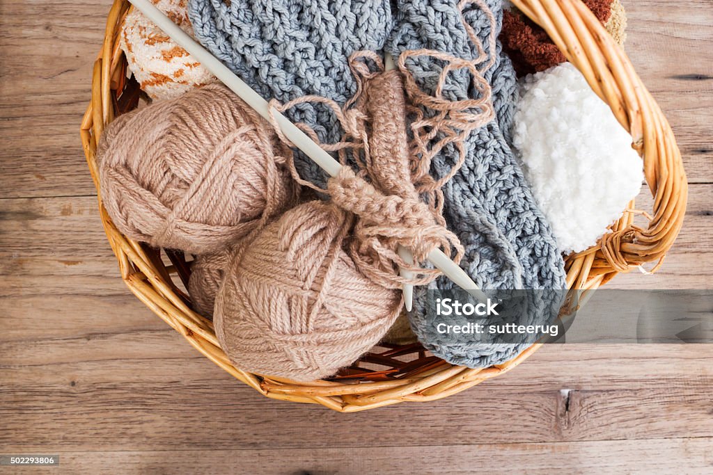 Knitting, handcraft. Knitting yarn and needlecraft in a basket on wooden background. Top view. 2015 Stock Photo