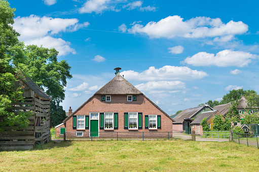 Characteristic landscape on the island of Öland (Sweden) with wooden mill and a farmhouse painted red and white