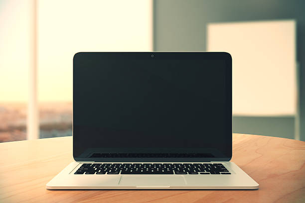 istock Blank black laptop screen on wooden table 502295670