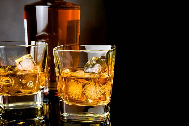 istock whiskey with ice in glasses in front of bottle 502295738