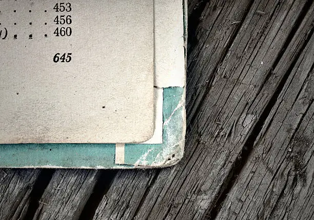 Open pages of old shabby books on a background of aged wood facing