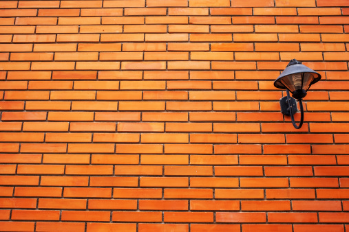 Lamp on orange brick wall