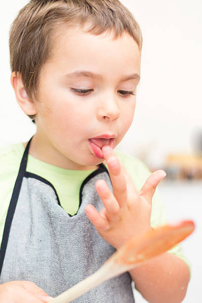 istock Little boy licks his fingers 502299217